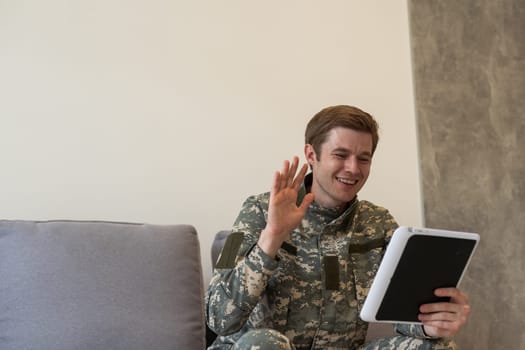 cheerful military man using digital tablet and having video call in office.