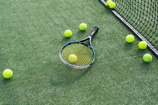 High angle view of tennis racket and ball by marking on grassy land at tennis court. Copy space, unaltered, sport, competition, green, nature and summer concept. High quality photo