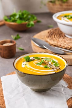 Delicious homemade creamy pumpkin soup with cream with sesame seeds and watercress.