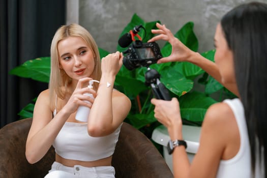 Two beautiful content creator making natural beauty and cosmetic tutorial on green plant garden video. Beauty blogger showing how to beauty care to social medial audience using selfie stick . Blithe