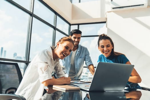 Group of diverse profession business people pointing at laptop displayed idea. Portrait of business team show marketing strategy present by laptop with statistic document scatter on table. Tracery.