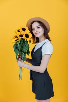 Woman in a hat with a bouquet of daisies