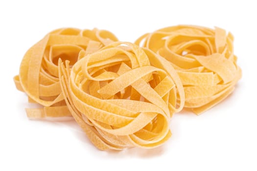 Three Classic Italian Raw Egg Fettuccine - Isolated on White Background. Dry Twisted Uncooked Pasta. Italian Culture and Cuisine. Raw Golden Macaroni Pattern - Isolation