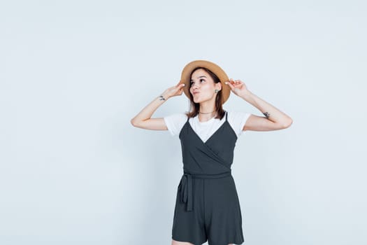 woman in hat posing on white background in studio