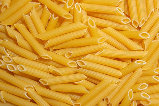 Uncooked Penne Rigate Pasta: A Culinary Canvas of Penne Macaroni, Creating a Lively and Textured Background for Gourmet Cooking. Dry Pasta. Raw Macaroni - Top View, Flat Lay