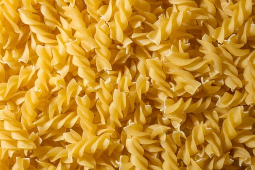 Uncooked Fusilli Pasta: A Culinary Canvas of Spiral Macaroni, Creating a Lively and Textured Background for Gourmet Cooking. Dry Pasta. Raw Macaroni - Top View, Flat Lay