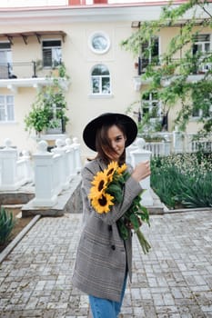 Woman in a hat with flowers posing for a walk
