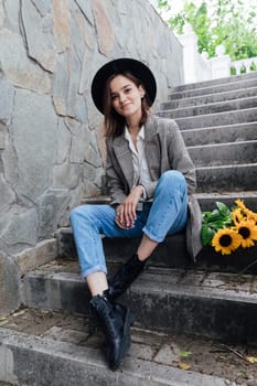 Woman in a hat with flowers posing for a walk