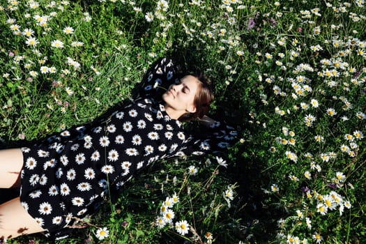 chamomile woman lying in field in flowers in nature walk journey