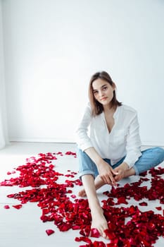 Woman in rose petals sitting indoors red