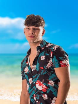 Attractive, muscular young man smiling, wearing open hawaian style shirt on a beach
