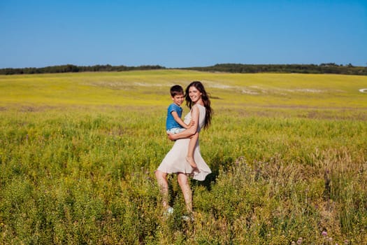 Mom and son in a field with flowers on a walk