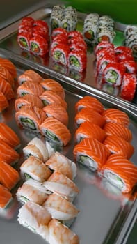 Sushi and rolls with caviar, shrimp and tuna, avocado on a gray background. Copy space