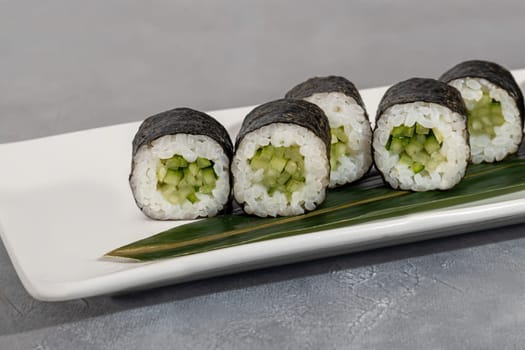 Sushi and rolls with caviar, shrimp and tuna, avocado on a gray background. Copy space