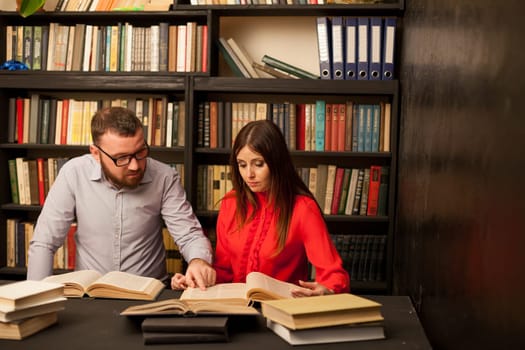 a man and a woman read a lot of books in the library 1