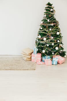 Christmas tree with gifts for the new year in the interior of the white room