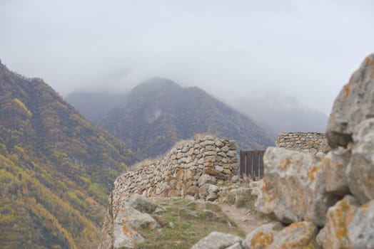 Cloudy foggy sky, mountain peaks covered with fog in the morning. Caucasus Mountains, Upper Balkaria, Russia