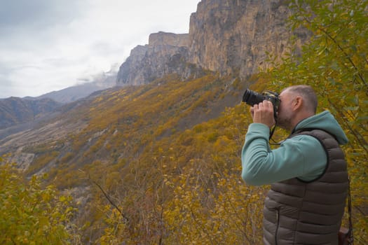 Male nature photographer takes pictures in the mountains.