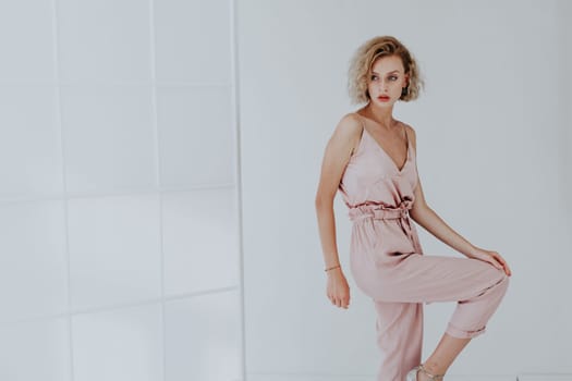 Portrait of a beautiful woman in a pink jumpsuit