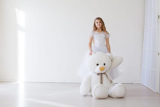 girl holds a large soft toy polar bear