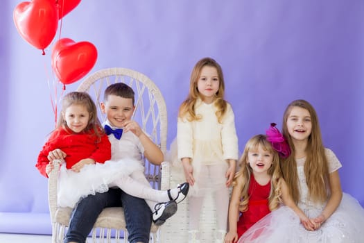 girls and boy with red balloons in the shape of a heart