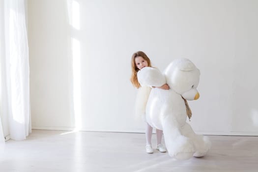 girl holds a large soft toy polar bear