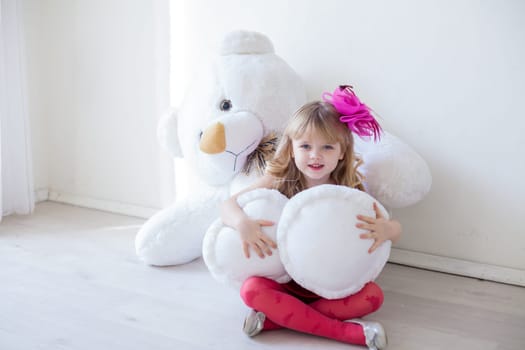 girl holds a large soft toy polar bear