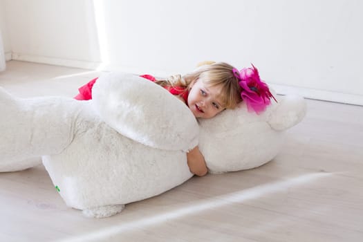 girl holds a large soft toy polar bear