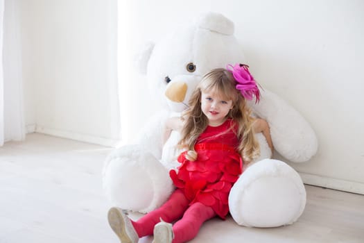 girl holds a large soft toy polar bear