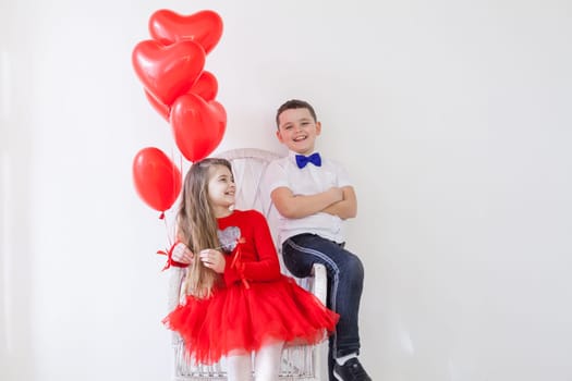 beautiful girl and boy with red balloons in the shape of a heart