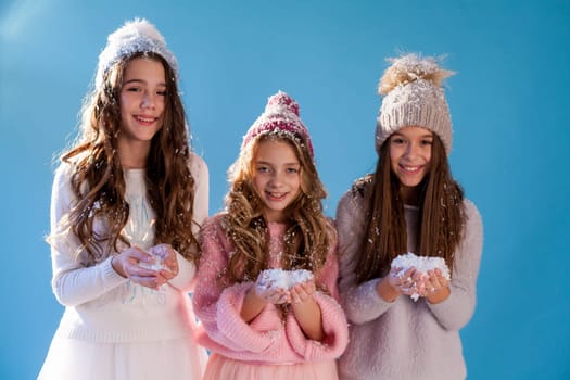 Three beautiful fashionable girls in winter cap snow chill January
