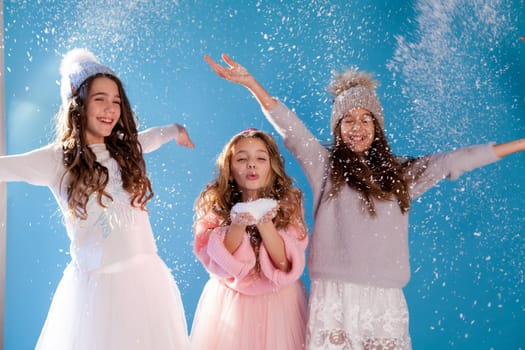 Three beautiful fashionable girls in winter cap snow chill January