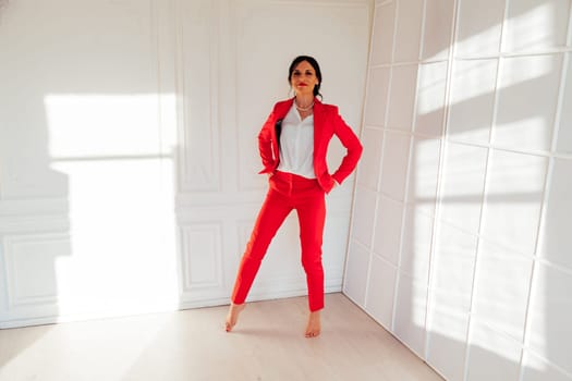 Portrait of a beautiful woman in a red business suit in the office
