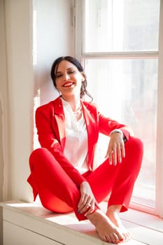 Portrait of a beautiful woman in a red business suit in the office