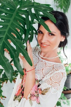 Portrait of a beautiful brunette woman with a green plant