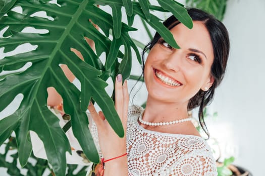Portrait of a beautiful brunette woman with a green plant