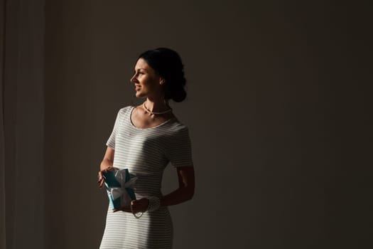 Portrait of a beautiful woman in a dress with a gift