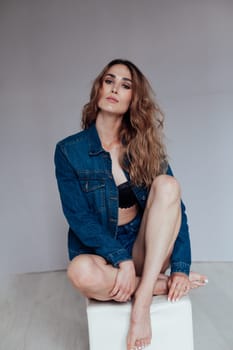 Portrait of a fashionable woman in denim shorts and lingerie