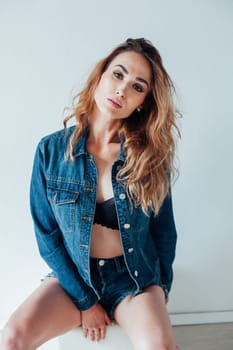 Portrait of a fashionable woman in denim shorts and lingerie