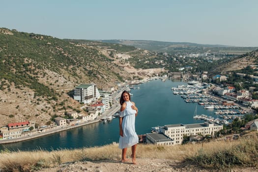 portrait of a woman with long hair in a dress on a cliff cliff by the sea