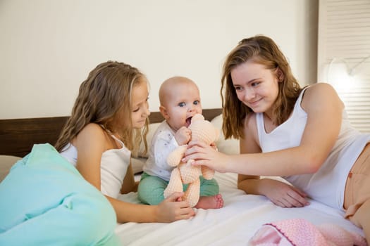 three girls sisters in the bedroom on the bed