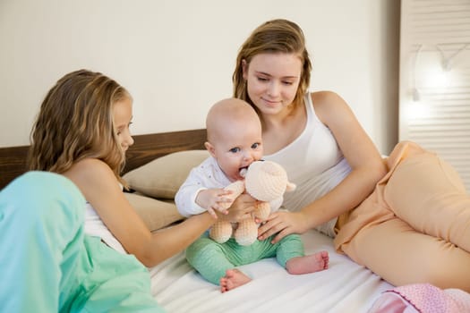 three girls sisters in the bedroom on the bed