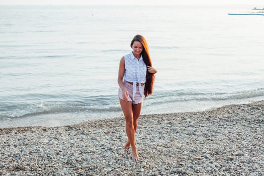 portrait of a woman with long hair on the beach by the sea