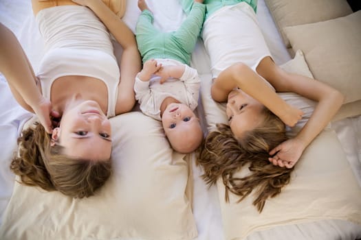 three girls sisters in the bedroom on the bed