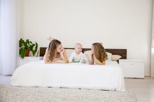 three girls sisters in the bedroom on the bed