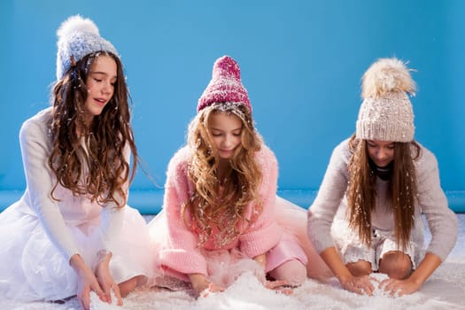 Three beautiful girl girlfriends in a hat cold winter snow