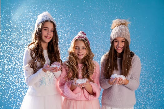 Three beautiful girl girlfriends in a hat cold winter snow