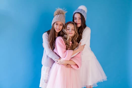 Three beautiful girl girlfriends in a hat cold winter snow