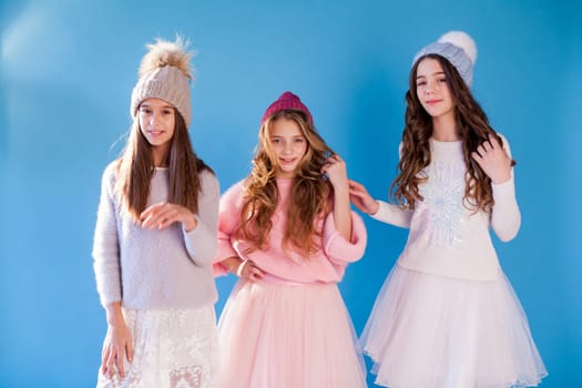 Three beautiful girl girlfriends in a hat cold winter snow