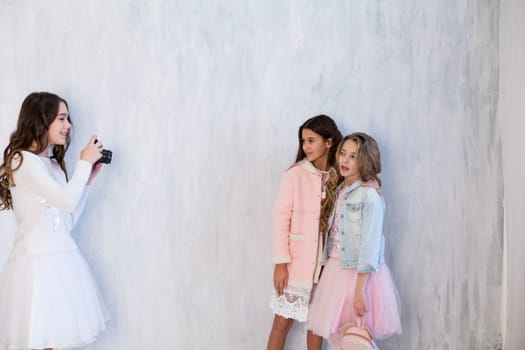 Two beautiful fashionable girls girlfriend in pink and white dresses at the photo shoot
